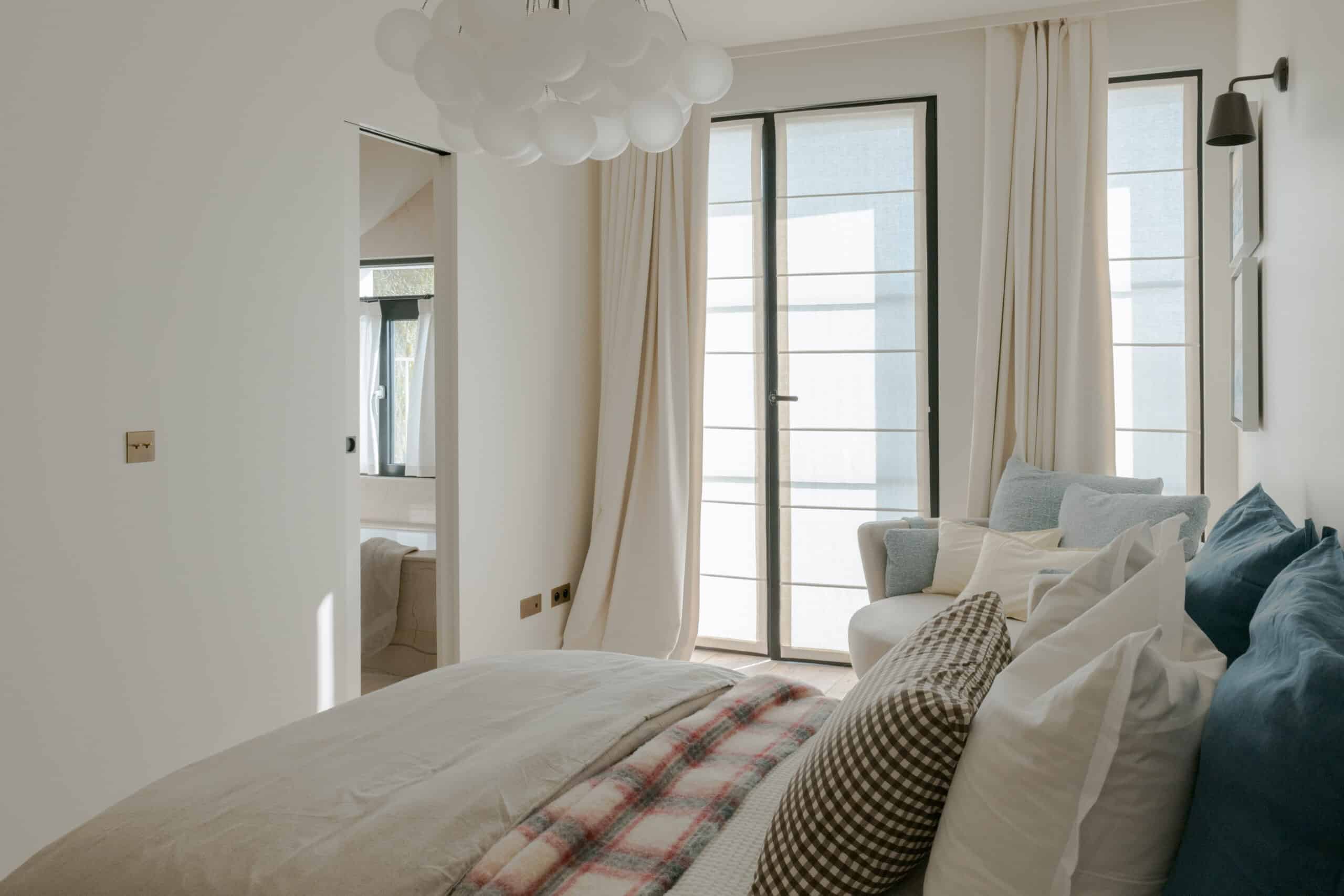 A tailor-made fireplace by Belgian brand Metalfire, defined by minimalist lines, anchors the room as a striking centerpiece, its flames coming alive in the winter months. The jewel-like side table features a glass top resting gracefully on an architectural base finished in sophisticated gold. Easy to move around, the occasional table  becomes an essential element of cocktail hour