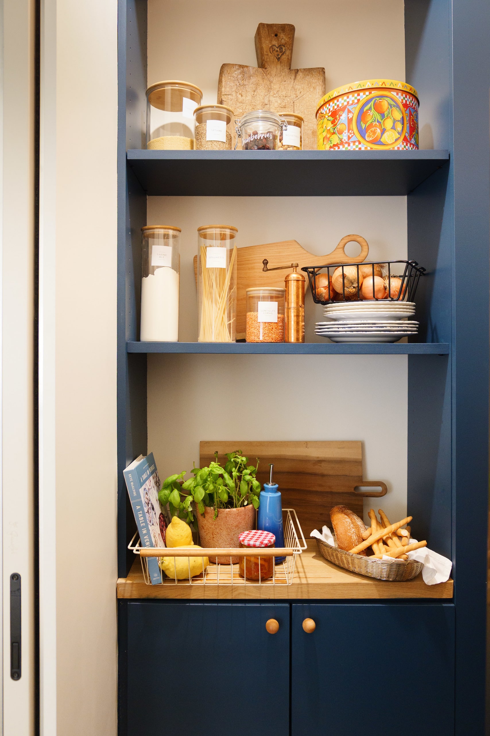 An eclectic ensemble of treasures on the marble floating shelf  glows under vintage 1970s German brass sconces from 1stDibs.
