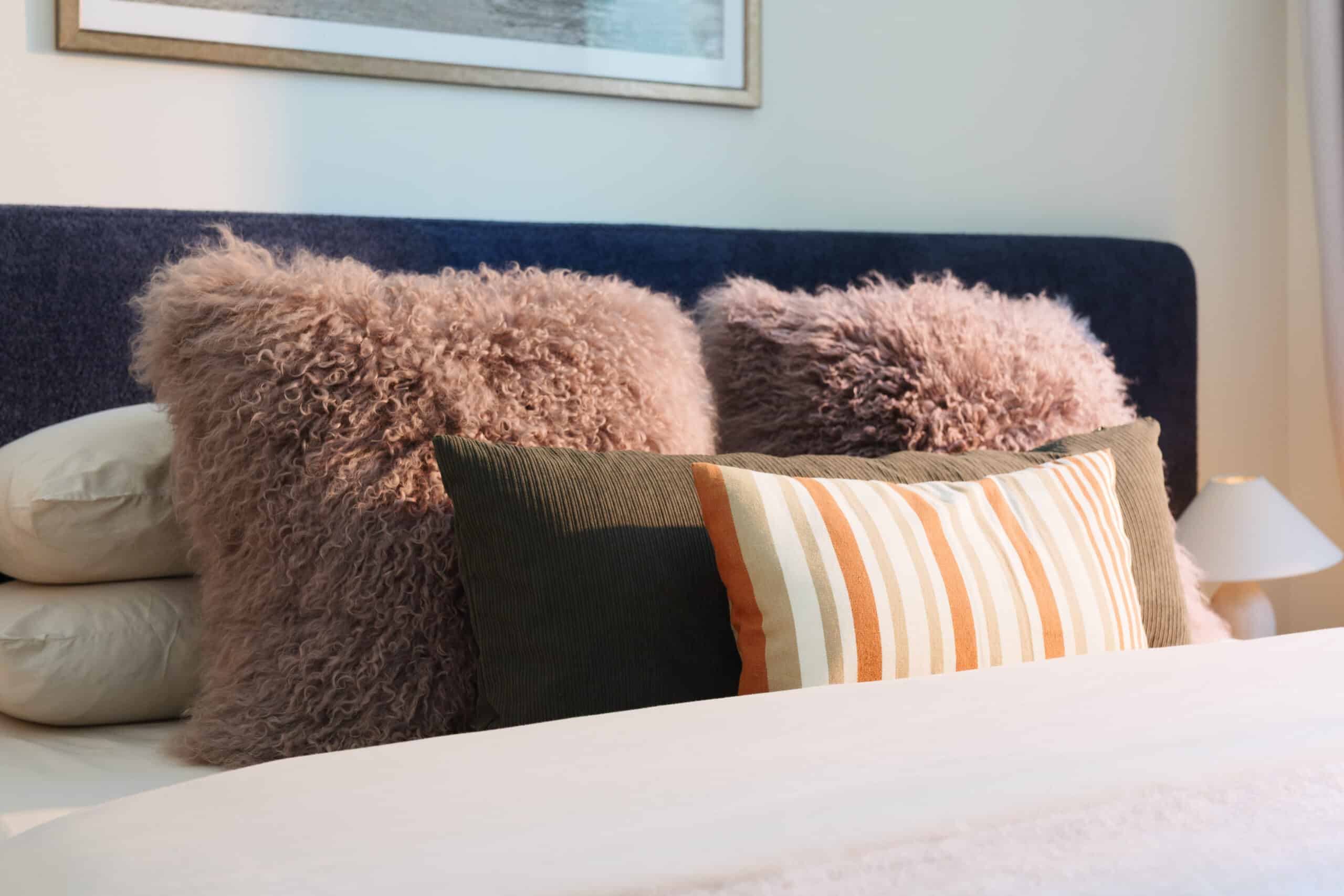 In keeping with the rest of the house, a quiet and serene second guest room with the same mix of vintage and custom designs. A bespoke dark blue bouclé bed and headboard by KS STUDIO DESIGN is paired with original Reguin side tables.The bespoke headboard fits the width of the room perfectly.