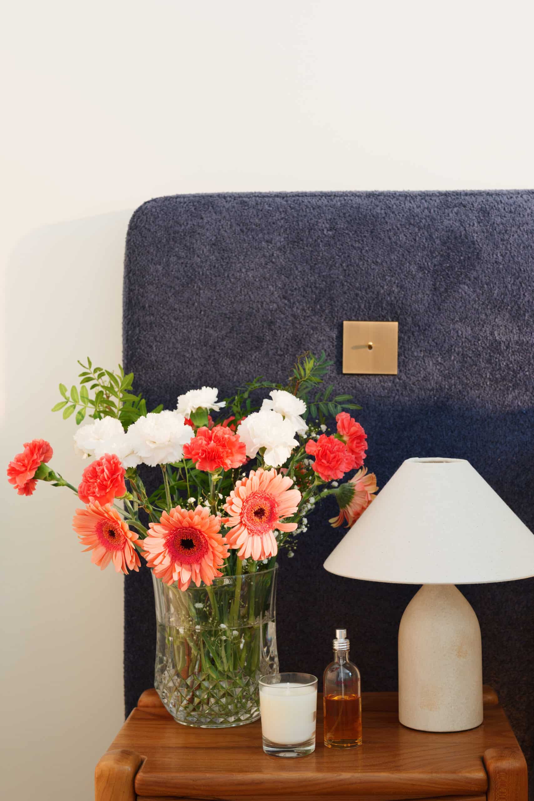 An eclectic ensemble of treasures on the marble floating shelf  glows under vintage 1970s German brass sconces from 1stDibs.