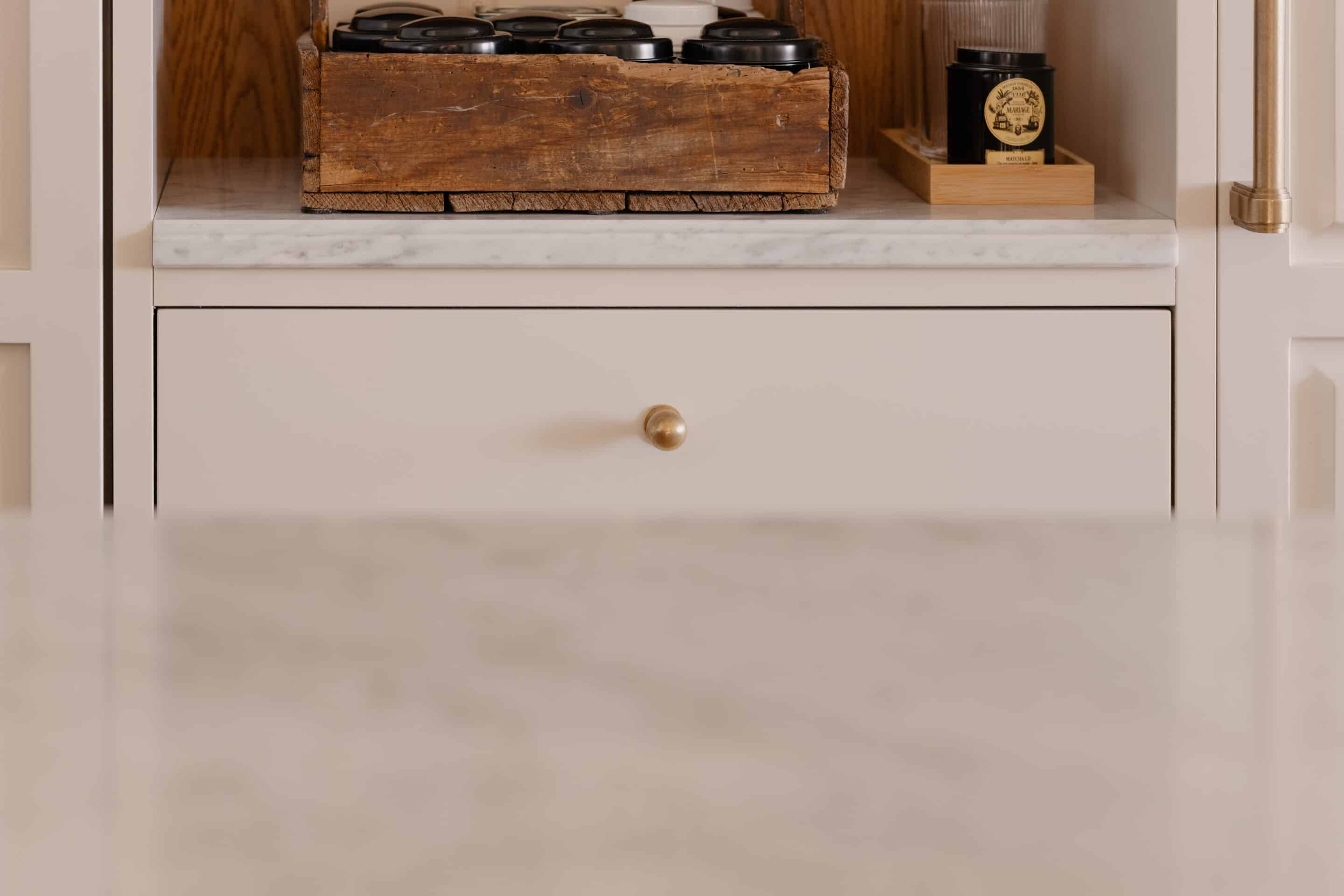 A tailor-made fireplace by Belgian brand Metalfire, defined by minimalist lines, anchors the room as a striking centerpiece, its flames coming alive in the winter months. The jewel-like side table features a glass top resting gracefully on an architectural base finished in sophisticated gold. Easy to move around, the occasional table  becomes an essential element of cocktail hour