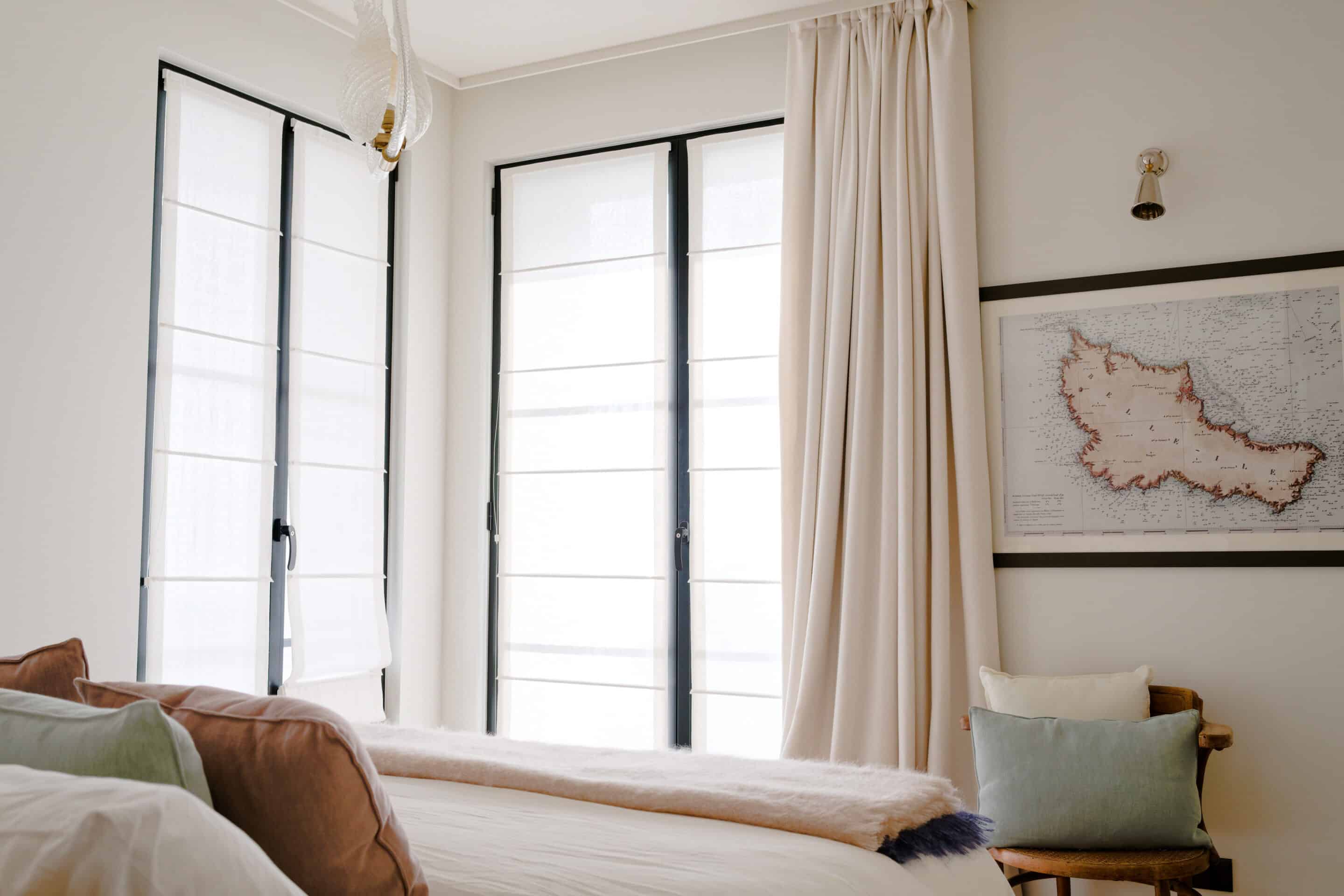In keeping with the rest of the house, a quiet and serene second guest room with the same mix of vintage and custom designs. A bespoke dark blue bouclé bed and headboard by KS STUDIO DESIGN is paired with original Reguin side tables.The bespoke headboard fits the width of the room perfectly.