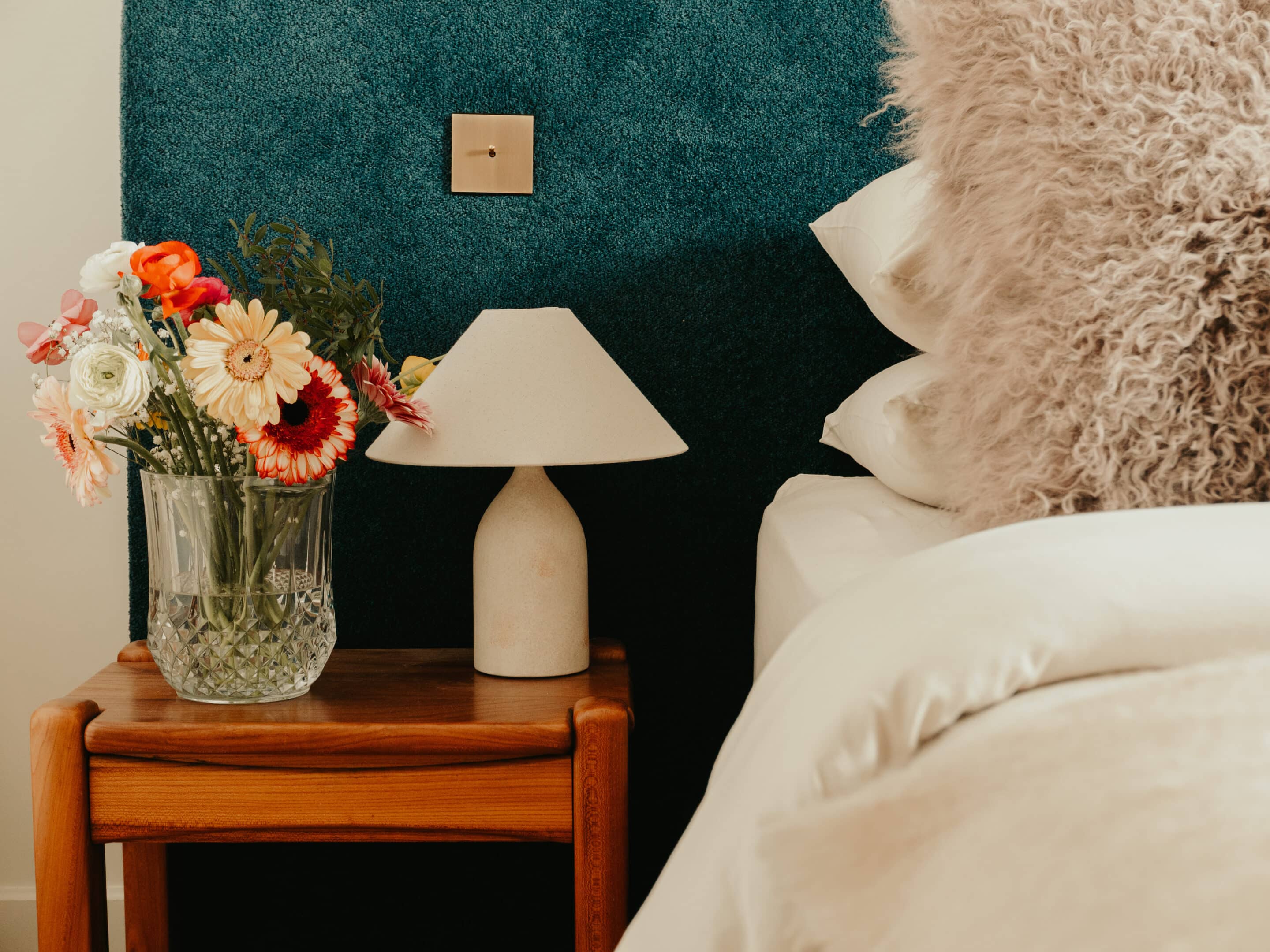 In keeping with the rest of the house, a quiet and serene second guest room with the same mix of vintage and custom designs. A bespoke dark blue bouclé bed and headboard by KS STUDIO DESIGN is paired with original Reguin side tables.The bespoke headboard fits the width of the room perfectly.